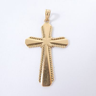 a gold cross pendant on a white background