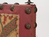 a picture of a red and gold pillow with studs on it