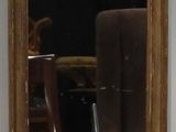 un miroir accroché au mur à côté d'une chaise