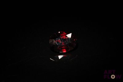 gros plan d'un diamant rouge sur une surface noire