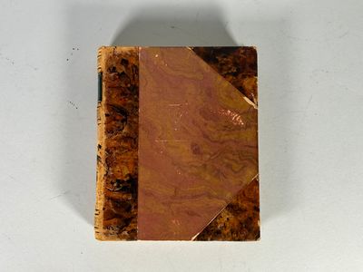 un petit livre à la couverture marron posé sur une table