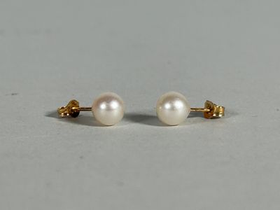 a pair of pearl earrings on a white surface