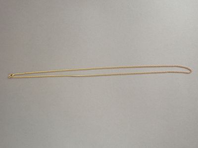 un collier en or dont l'extrémité est ornée d'une longue chaîne