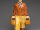 figurine of a man with a suitcase and hat on a pedestal
