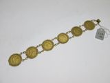 a close up of a gold bracelet on a white surface