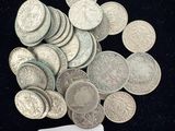 un tas de pièces d'argent sur lesquelles est collée une étiquette indiquant le prix
