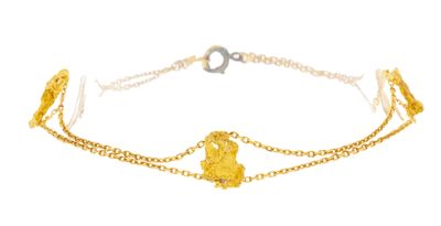 a close up of a gold chain bracelet with a heart on it