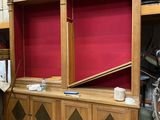 a large wooden entertainment center with a red screen behind it