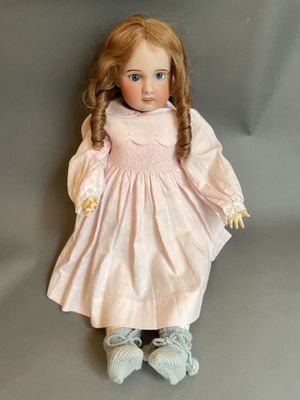 an image of a doll with red hair and a pink dress