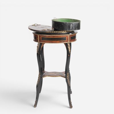a black and gold side table with a bowl on top of it