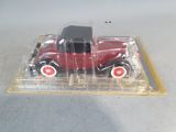 a red toy car in a clear box on a table