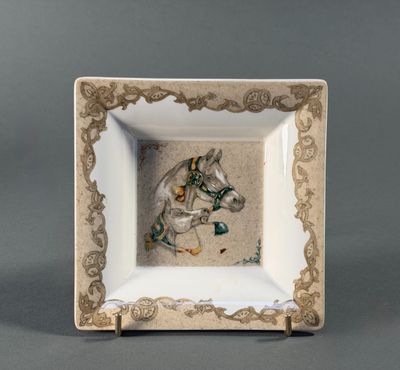 an image of a white and gold plate with a picture of a horse on it