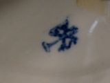 a blue and white vase with a blue flower on it