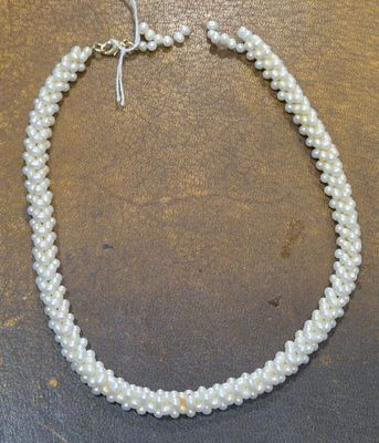 un gros plan d'un collier de perles blanches posé sur une table