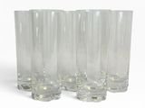 quatre verres transparents sont alignés sur une surface blanche