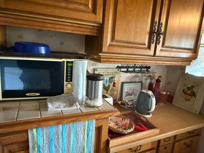 a microwave on a counter in a kitchen with wooden cabinets
