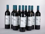 six bouteilles de vin sont alignées sur une table