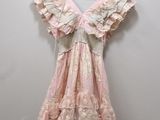 a pink dress hanging on a hanger against a white wall