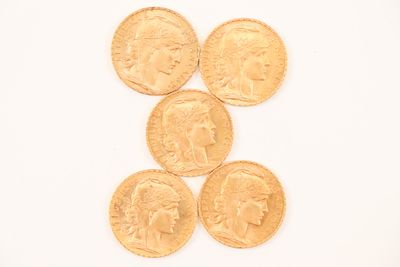 four gold coins are arranged in a pyramid on a white surface