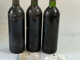 trois bouteilles de vin posées l'une à côté de l'autre sur une table