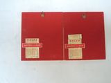 two red boxes with labels on them sitting on a white surface