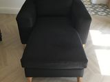 a black chair and ottoman in a living room