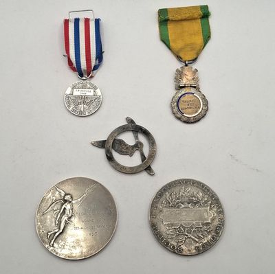 trois médailles et une médaille sur une surface blanche