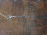 a close up of a dirty floor with a brown tile