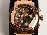 a rose gold watch with a black band on a white surface