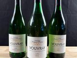trois bouteilles de vin posées sur une table en bois