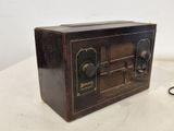 une vieille radio posée sur une table, à côté d'une paire de ciseaux