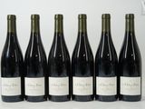 six bottles of wine are lined up in a row on a table