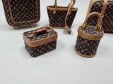four pieces of louis vuitton luggage sitting on top of a white surface