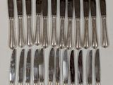 a lot of forks and knives on a table