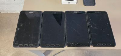three black iphones are sitting on a table next to a box