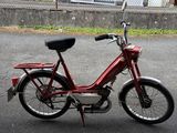 a red motorcycle parked on the street in front of a fence