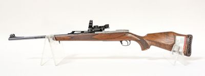 fusil posé sur un socle en acrylique transparent, sur une surface blanche, avec un fond blanc