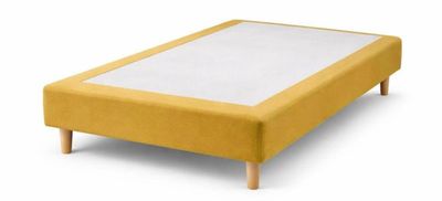 un cadre de lit rembourré jaune, avec des pieds en bois et un drap blanc posé dessus