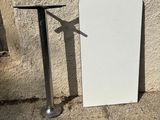 a white board sitting next to a table on the sidewalk