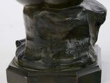 statue of a man holding a ball on a pedestal