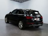 the back of a black audi qx parked in a white room
