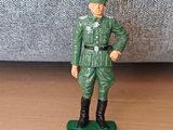 figurine représentant un homme en uniforme vert, debout sur un socle vert