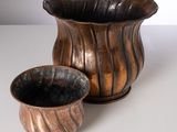 a brown vase and a brown cup sitting on a table