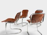 two brown leather chairs with chrome legs and a brown leather seat