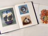 un livre ouvert avec l'image d'un vase et celle d'un chat