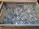 many empty glasses in a plastic container on the floor