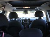 the interior of a small car with black seats and a pink handlebar