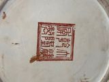 a close up of a white vase with red writing on it