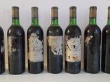 six bottles of wine are lined up in a row on a table