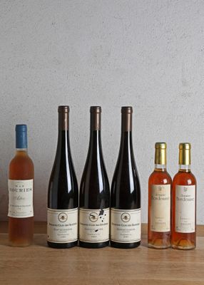 several bottles of wine are lined up on a wooden table